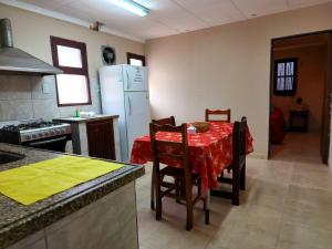 a kitchen with a table and a white refrigerator at Departamento Sarmiento in Rosario de la Frontera