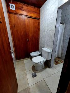 La salle de bains est pourvue de toilettes et d'une porte en bois. dans l'établissement Departamento Sarmiento, à Rosario de la Frontera