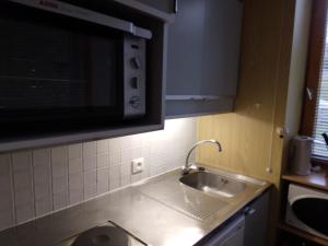a kitchen with a sink and a microwave at Studio Plagne Bellecôte, 1 pièce, 4 personnes - FR-1-181-2368 in La Plagne Tarentaise