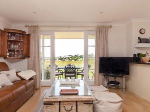 a living room with a couch and a tv at 5 Thurlestone Beach in Kingsbridge