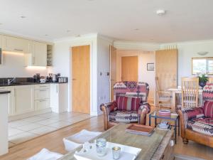 a kitchen and living room with two chairs and a table at 5 Thurlestone Beach in Kingsbridge
