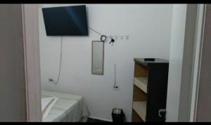 a room with a white wall with a mirror at Pousada Landus in São Paulo