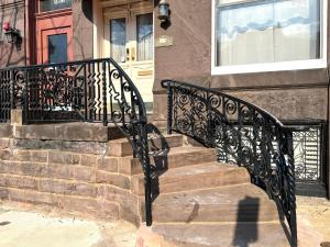 a wrought iron stair railing in front of a house at Alina & Fanny - Philadelphia S Broad St in Philadelphia