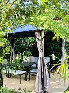 einen Pavillon mit einem Tisch und Stühlen im Garten in der Unterkunft South Pacific Bed & Breakfast in Clifton Beach