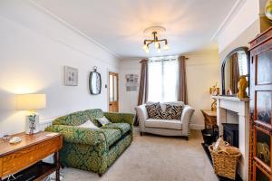 uma sala de estar com um sofá e uma cadeira em Marina's Cottage em Lowestoft