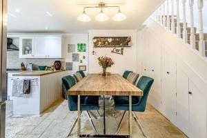 a kitchen and dining room with a wooden table and chairs at Marina's Cottage in Lowestoft