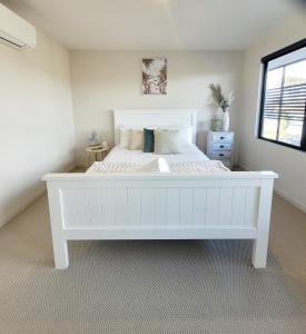 a large white bed in a room with a window at Waters Edge Apartment in Rye