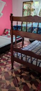 a bedroom with a wooden bed in a room at Akogo House - Hostel and Backpackers in Mombasa