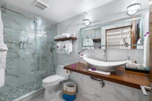 ein Badezimmer mit Toilette, Waschbecken und Dusche in der Unterkunft Spectacular luxury , modern oceanfront condo Maalaea-Kihei ,Maui in Wailuku