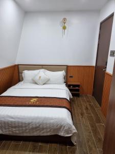 a bedroom with a large bed with a cross on the wall at Hotel Trí Lê in Cao Lãnh