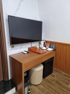 a desk with a flat screen tv on top of it at Hotel Trí Lê in Cao Lãnh