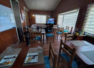 a dining room with tables and chairs and a television at Hospedaje Valencia in Puerto Montt