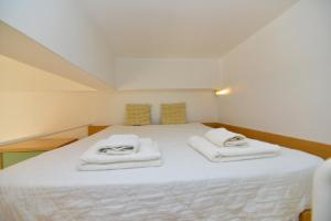 1 dormitorio con 1 cama con toallas en Athens cozy Studio 4 min walk to the Acropolis hil, en Atenas