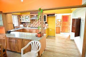 a kitchen with orange walls and wooden cabinets at Kollakudy HomeStay in Paravūr