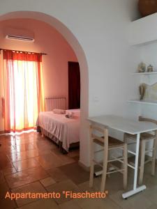 a room with a table and a bed and a window at Ramasole in Ostuni +37 photos