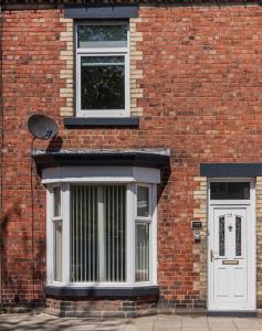 a brick building with a white door and window at Number Sixteen in Bishop Auckland