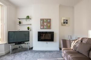 a living room with a couch and a flat screen tv at Number Sixteen in Bishop Auckland