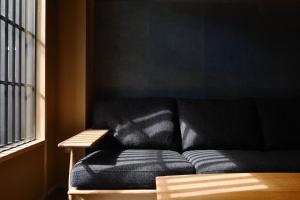 a black couch in a room with a window at Kyoyado Heianshiki in Kyoto
