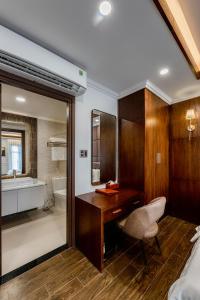 a bathroom with a desk and a sink and a tub at Hotel Trí Lê in Cao Lãnh