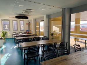 - un restaurant avec des tables et des chaises en bois dans une chambre dans l'établissement Auberge de jeunesse HI Clermont-Ferrand, à Clermont-Ferrand