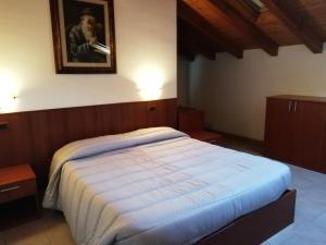 a bedroom with a bed and a picture on the wall at Locanda Rita in Pontey