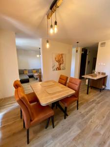 comedor con mesa de madera y sillas en New Apartment with balcony and free parking, en Zadar
