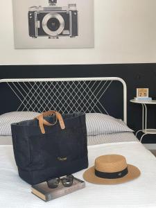 torba i kapelusz na łóżku z kamerą w obiekcie Apartament Steyera w Świnoujściu