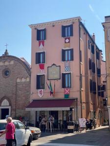 a man is standing in front of a building at Duomo Boutique Hotel in Chioggia