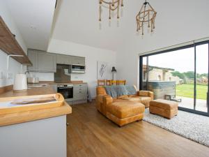 a kitchen and living room with a couch and a table at Owl Lodge in Wedmore