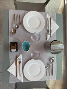 a table with white plates and silverware on it at Casale al Foino in Induno Olona