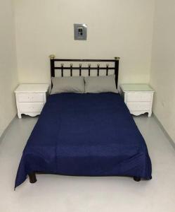 a bedroom with a blue bed and two white night stands at Cerca de Parque industrial Nava 3 hab (Facturable) in Ciudad Obregón