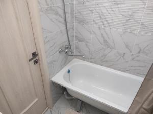 a bathroom with a white tub and a sink at Светлая и уютная квартира в южной части Бишкека! in Bishkek