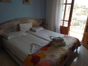 a bedroom with a large white bed with a colorful blanket at Amversa's Rooms in Skala Marion