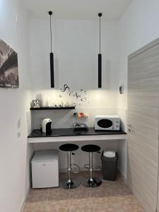 een keuken met 2 barkrukken en een magnetron bij Andrea Accomodation in Tropea