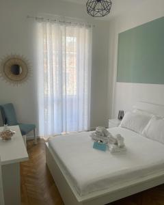 ein weißes Schlafzimmer mit einem Bett und einem Fenster in der Unterkunft VERDE Ridi Che Ti Passa in Alassio