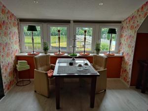 - une salle à manger avec une table, des chaises et des fenêtres dans l'établissement Gasthaus Düther Schleuse, à Düthe