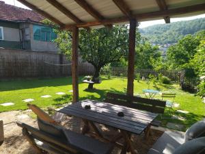 una mesa de picnic de madera y sillas bajo una pérgola en Konak Garavi sokak en Kuršumlija