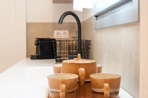 a kitchen with two wooden chairs and a sink at Paris Studios & Apartment in Agia Paraskevi