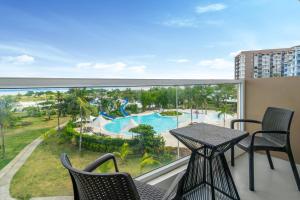 a balcony with a table and chairs and a view of a pool at Solea Seaview Resort in Mactan