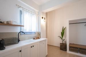 une cuisine blanche avec un évier et une fenêtre dans l'établissement Paris Studios & Apartment, à Agia Paraskevi 37 autres photos