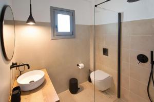 a bathroom with a toilet and a glass shower at Paris Studios & Apartment in Agia Paraskevi