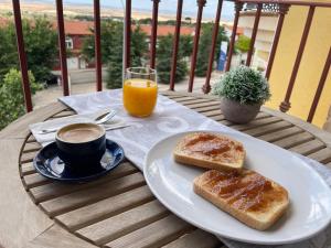 a table with toast and a cup of coffee and orange juice at Apartamento Levante en Chinchilla con vistas in Chinchilla de Monte Aragón