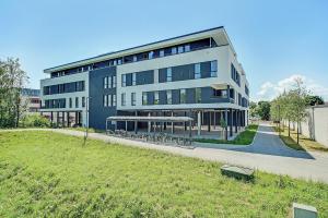 a large building with a lawn in front of it at BRIGHT: Rosenheim Aicherpark in Rosenheim
