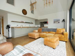 a living room with couches and chairs and a kitchen at Starling Lodge in Wedmore