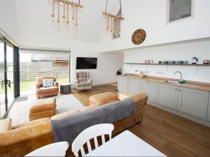 a living room with a couch and a kitchen at Starling Lodge in Wedmore