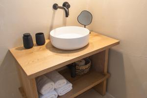 a white bowl on a wooden shelf in a bathroom at Paris Studios & Apartment in Agia Paraskevi