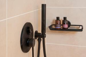 two bottles of essential oils sitting on a holder on a bathroom door at Paris Studios & Apartment in Agia Paraskevi