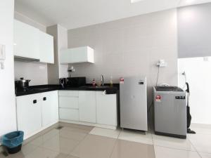 a kitchen with white cabinets and a refrigerator at Exclusive Homestay at Central Residence, Kuala Lumpur in Kuala Lumpur