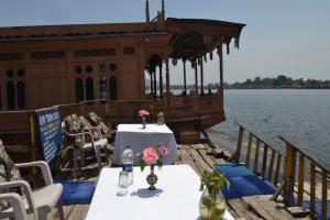 una mesa y sillas en un barco en el agua en Palace Heights en Srinagar