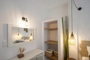 a white room with a mirror and a bed at Paris Studios & Apartment in Agia Paraskevi
